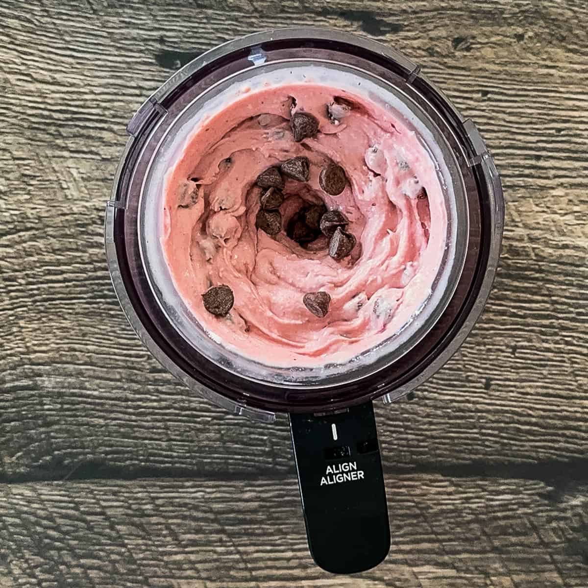 Cherry chocolate chip ice cream in the outer bowl after the chocolate chips are mixed in.