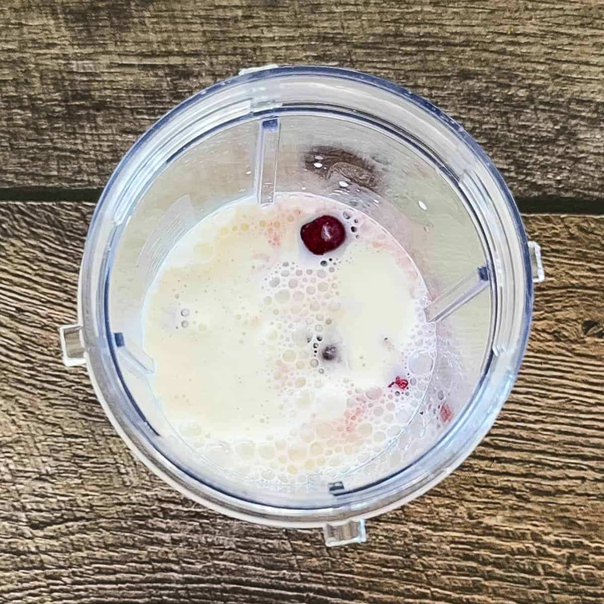Cherry ice cream mixture in blender before blending.