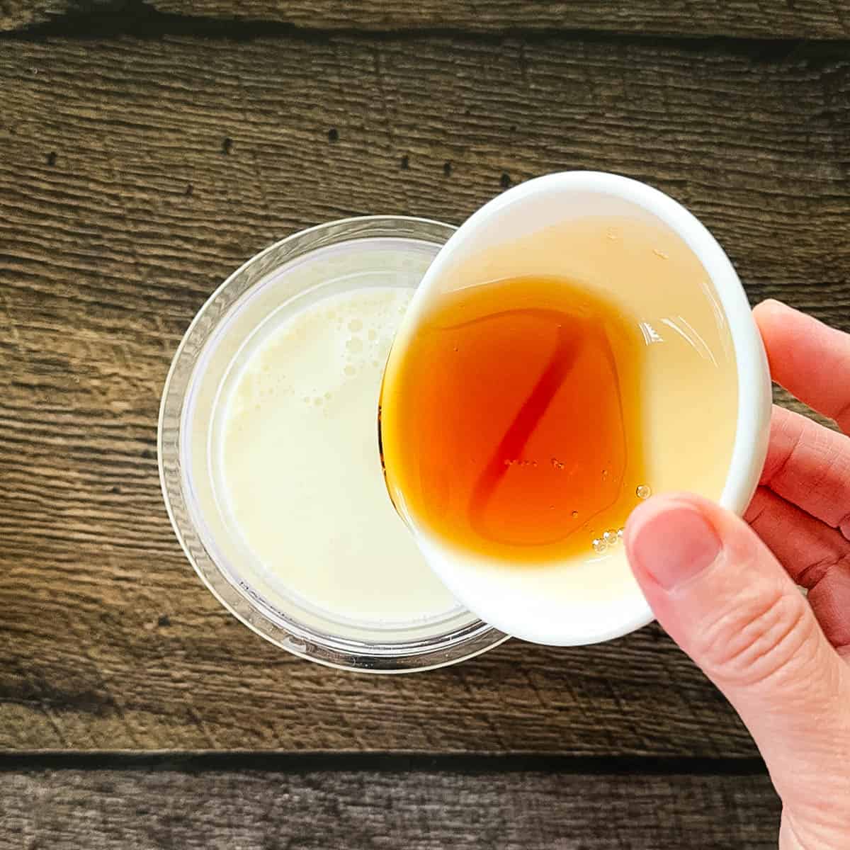 Maple syrup being poured into the pint container with the milk and cream.