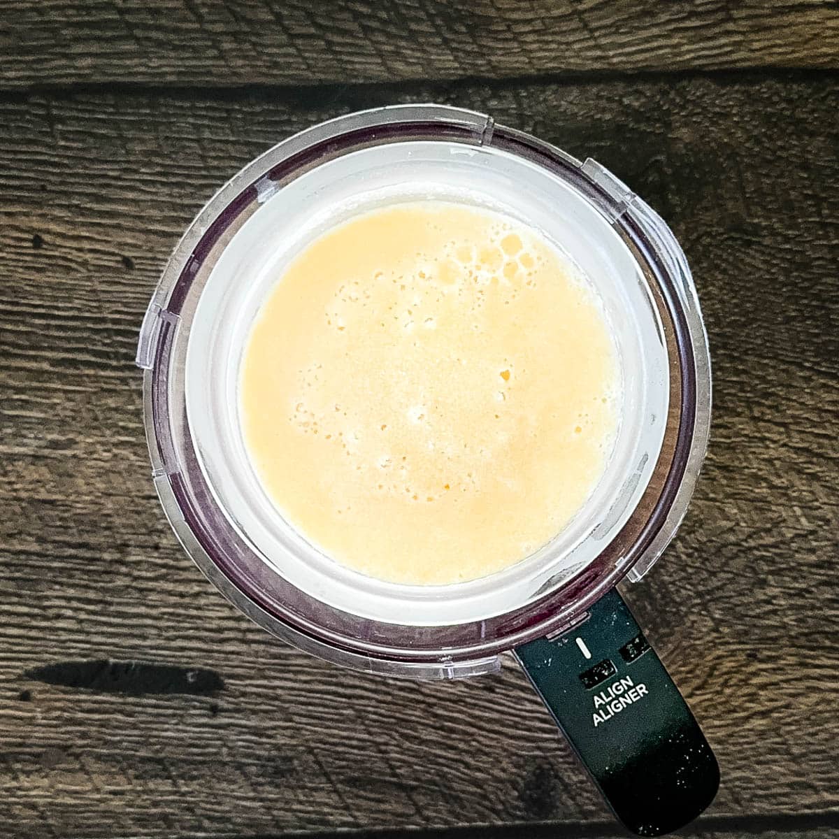 The frozen maple mixture in the Ninja Creami outer bowl, ready to process.