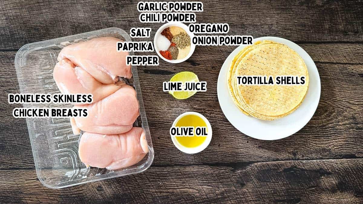 Labeled ingredients for smoked chicken tacos placed on a wooden table.