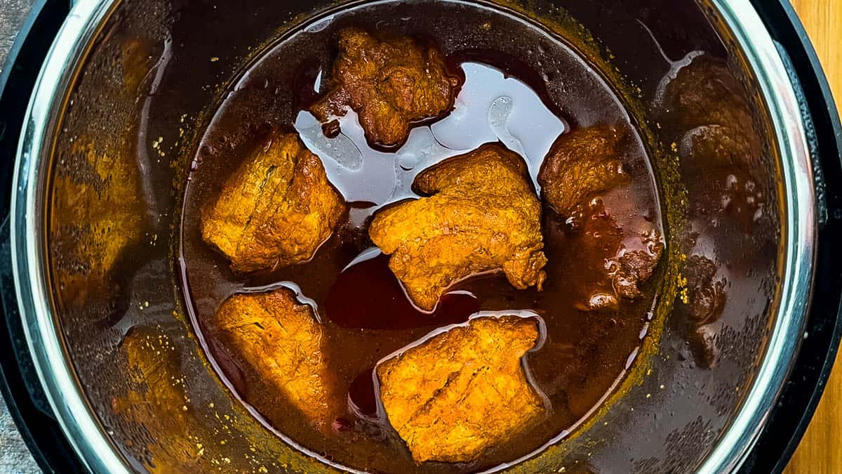 Cooked pork tenderloin in rich BBQ sauce inside the Instant Pot after cooking.