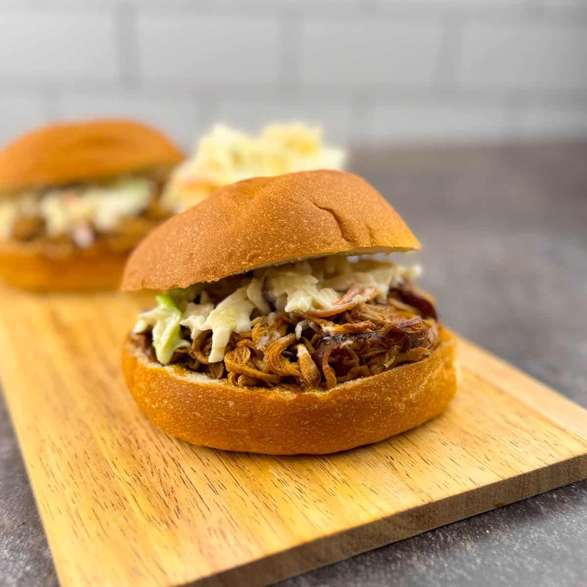 BBQ pulled pork tenderloin sandwich on a toasted bun topped with creamy coleslaw.