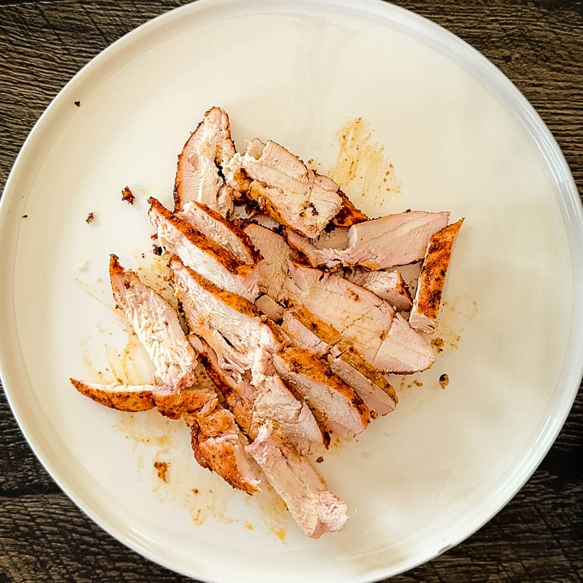 Thinly sliced chicken on a white plate.