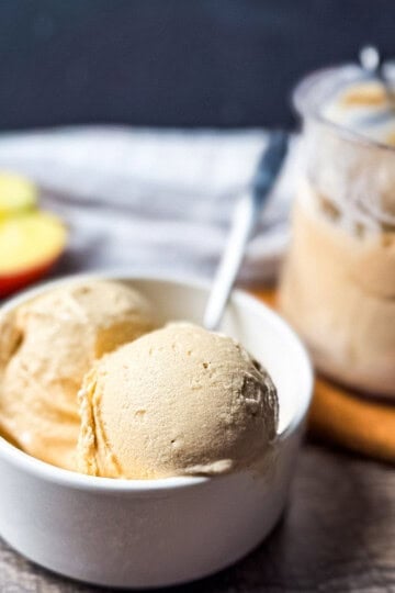 Creamy apple pie ice cream scoops in a white bowl with a spoon, made in the Ninja Creami ice cream maker.