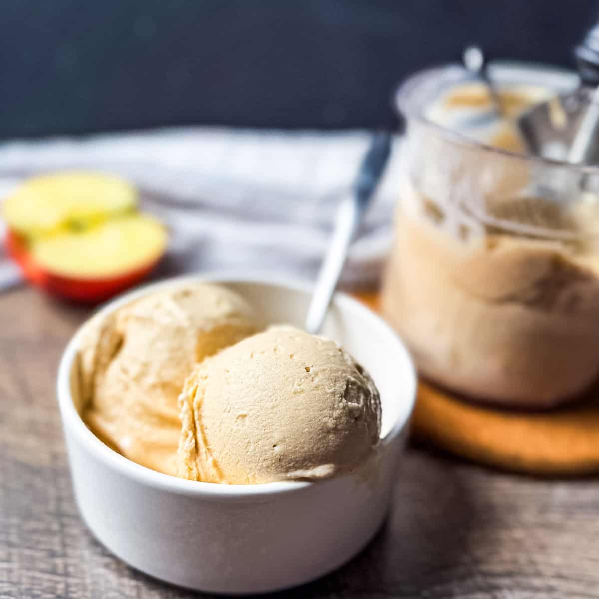 Creamy apple pie ice cream scoops in a white bowl with a spoon, made in the Ninja Creami ice cream maker.