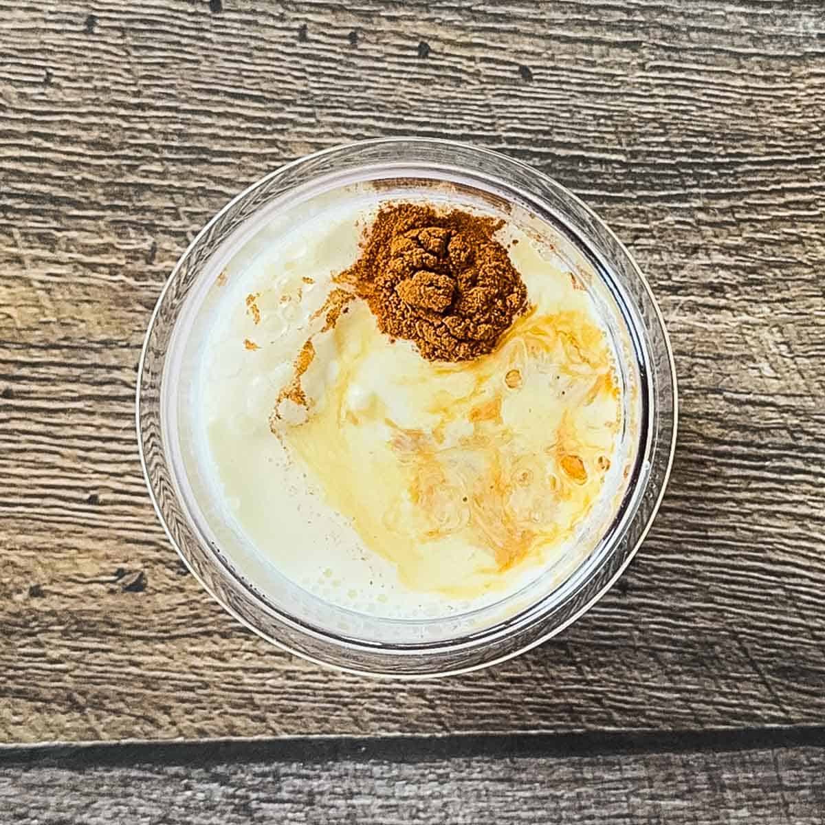 Apple pie ice cream ingredients in a Ninja Creami pint jar.