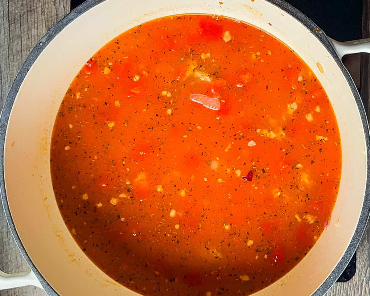 Rich tomato broth simmering in a pot.