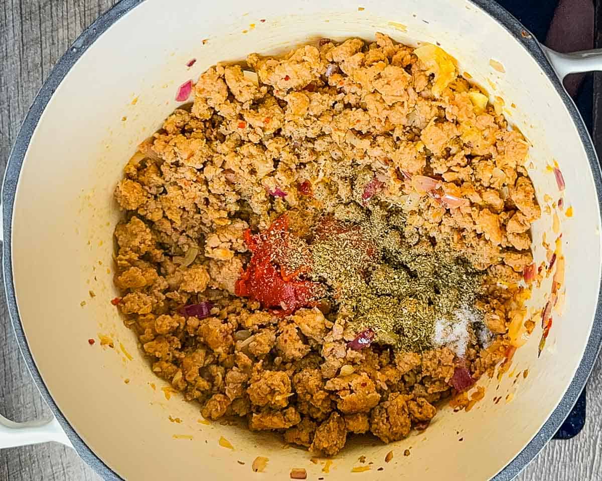Tomato paste and seasonings added to the large Dutch oven.