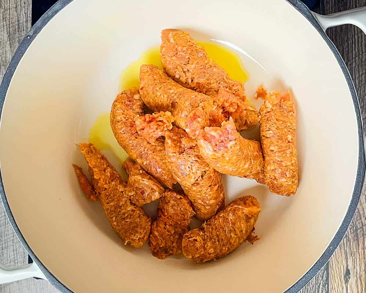 Italian sausage squeezed out of the casing in a large Dutch oven.