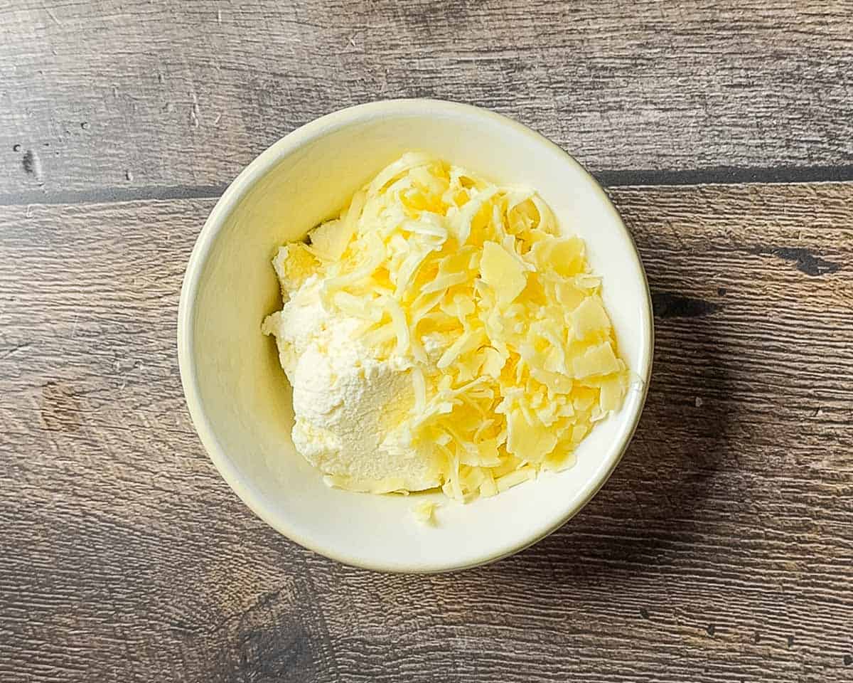 Three types of cheese in a small mixing bowl.