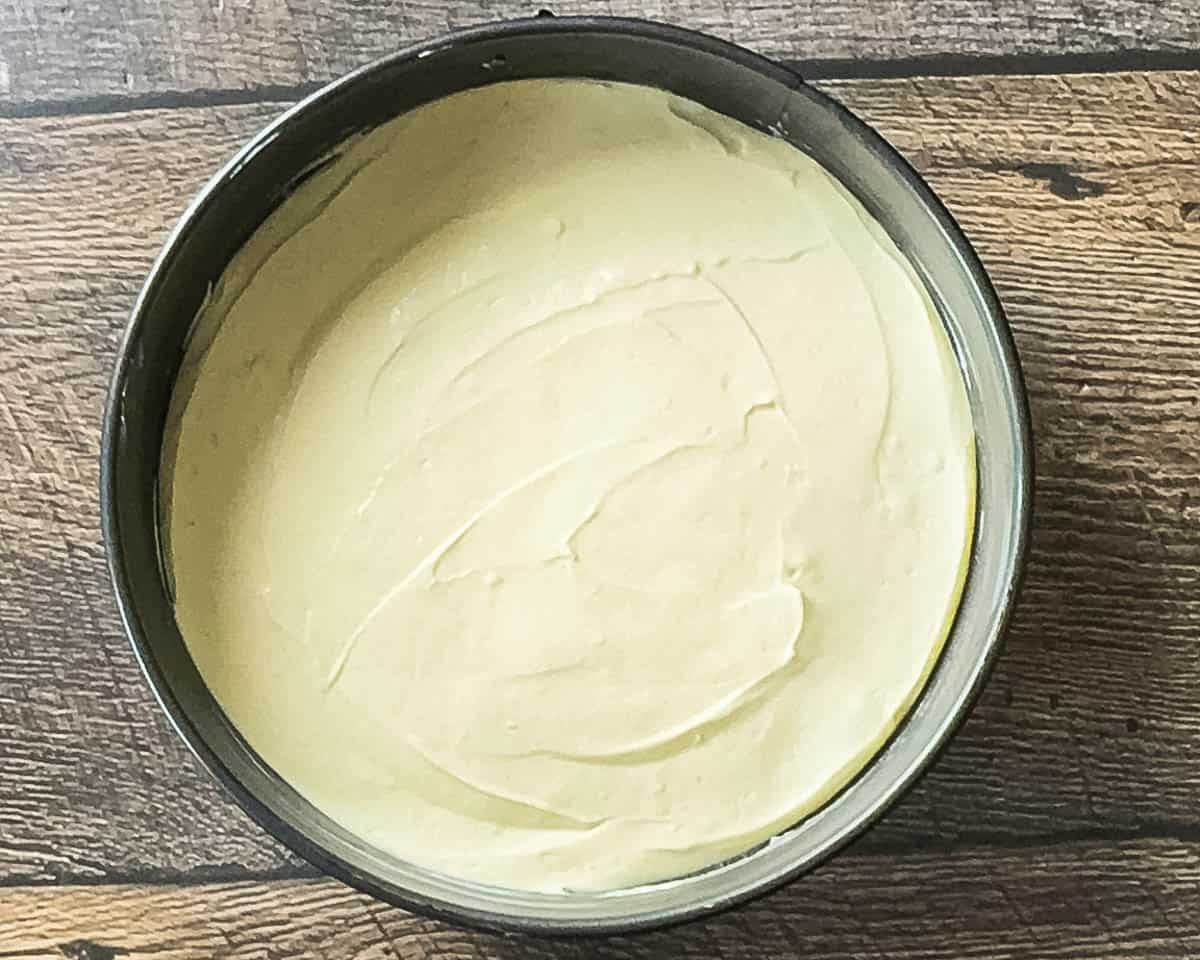 Unbaked cheesecake in a springform pan with a smooth, even layer of filling ready to be placed on the smoker.