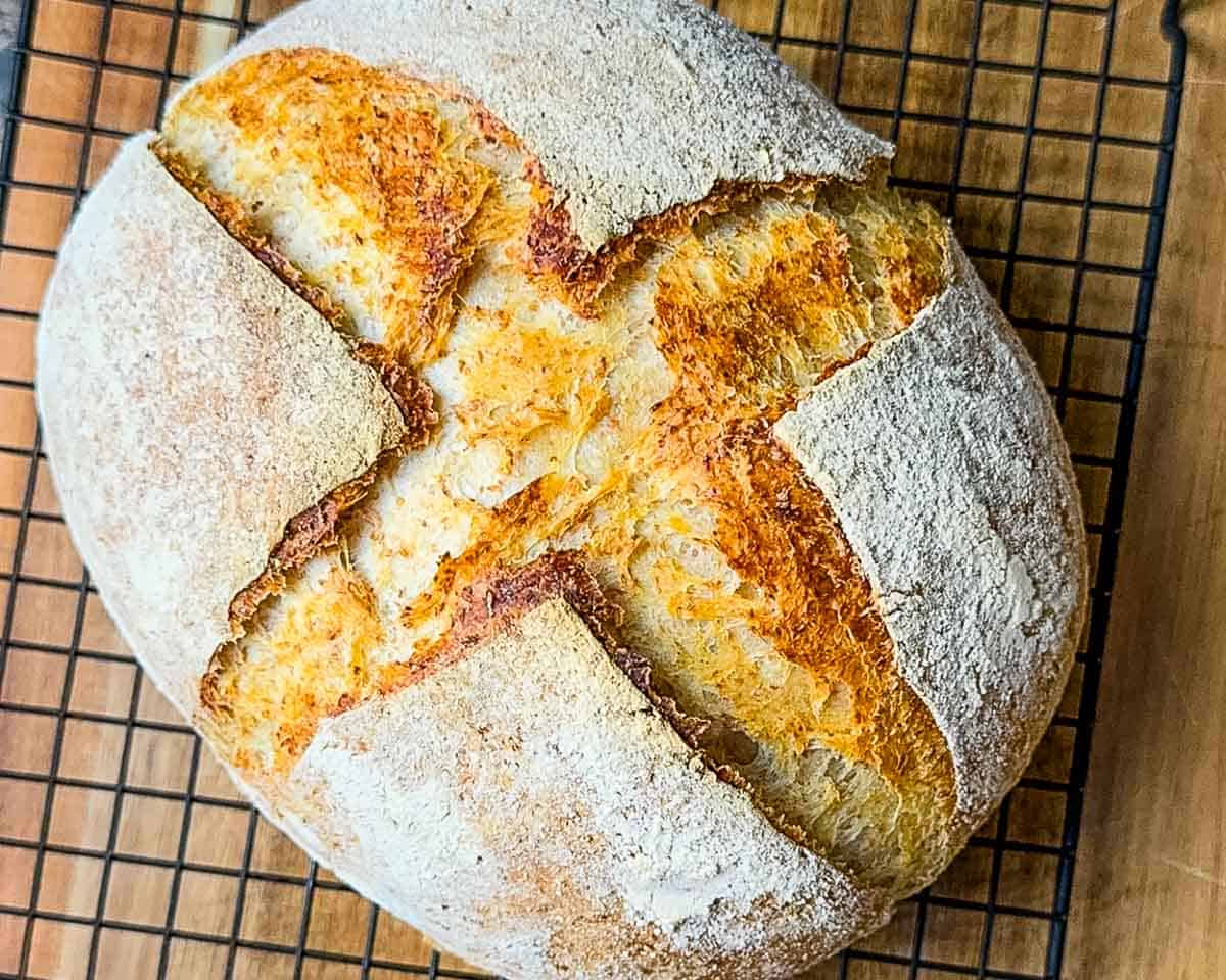 The whole wheat sourdough bread cooling on a wire rack as soon as it comes out of the oven.