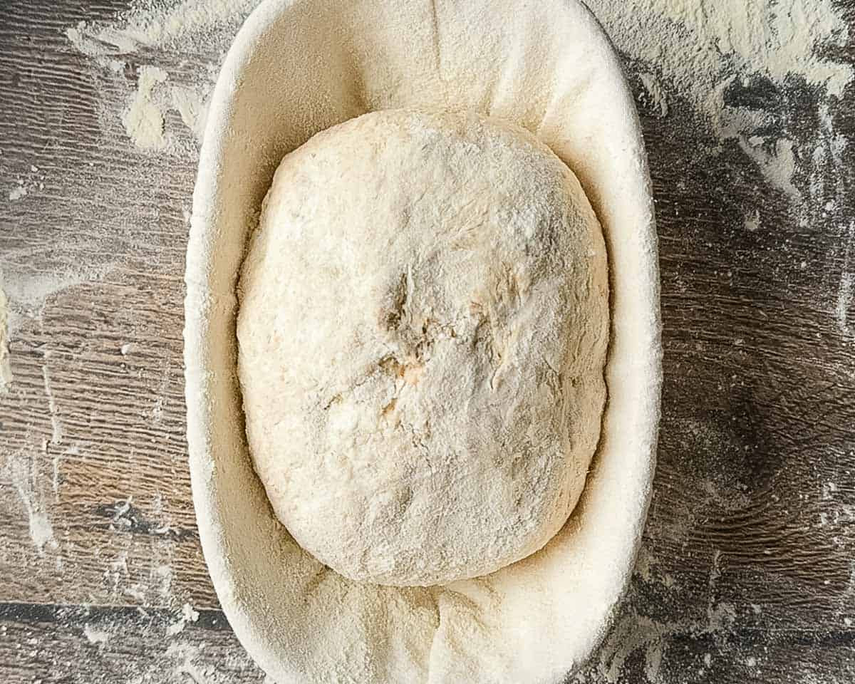 The lightly floured dough in a banneton basket.