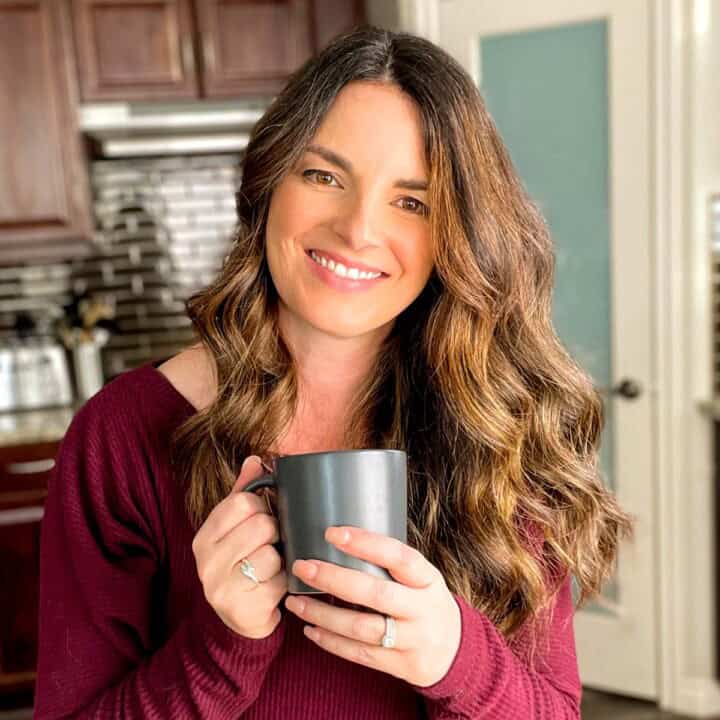 A photo of Jeri Walker smiling in her kitchen while holding a cup of coffee, welcoming her readers to her website, Winding Creek Ranch.