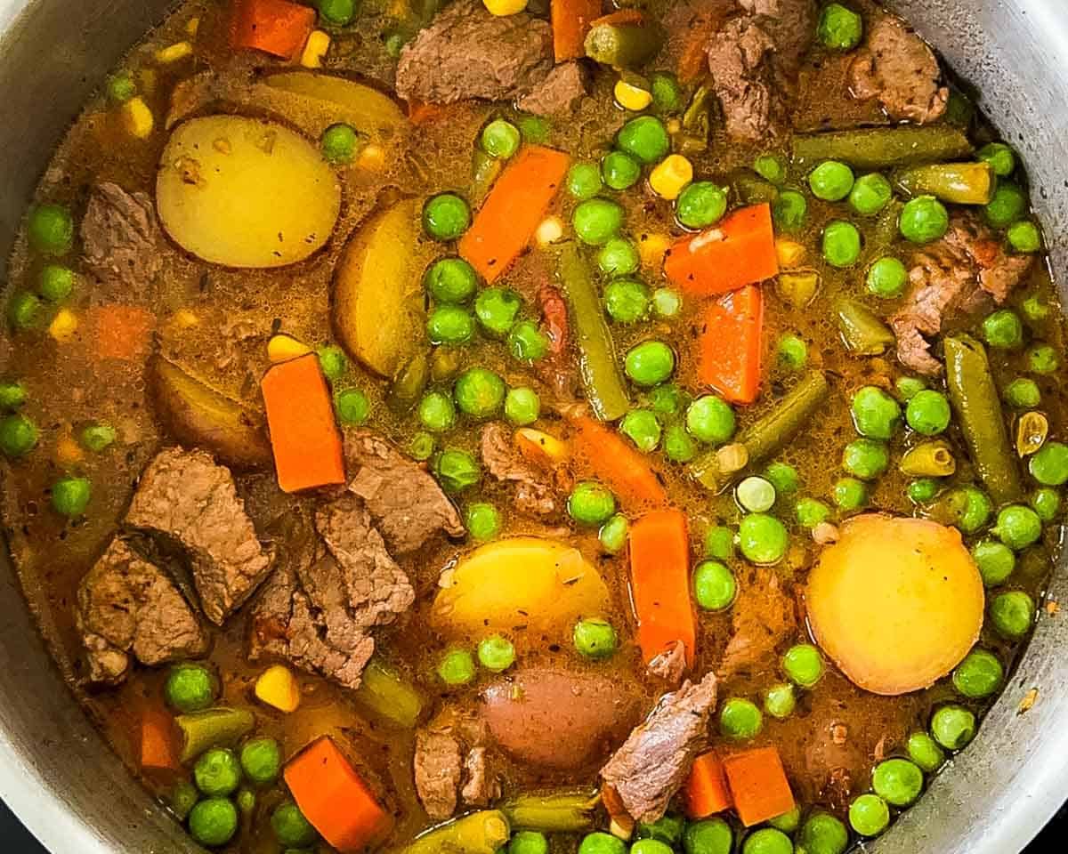 Finished old-fashioned beef vegetable soup loaded with beef and vegetables in the pot.