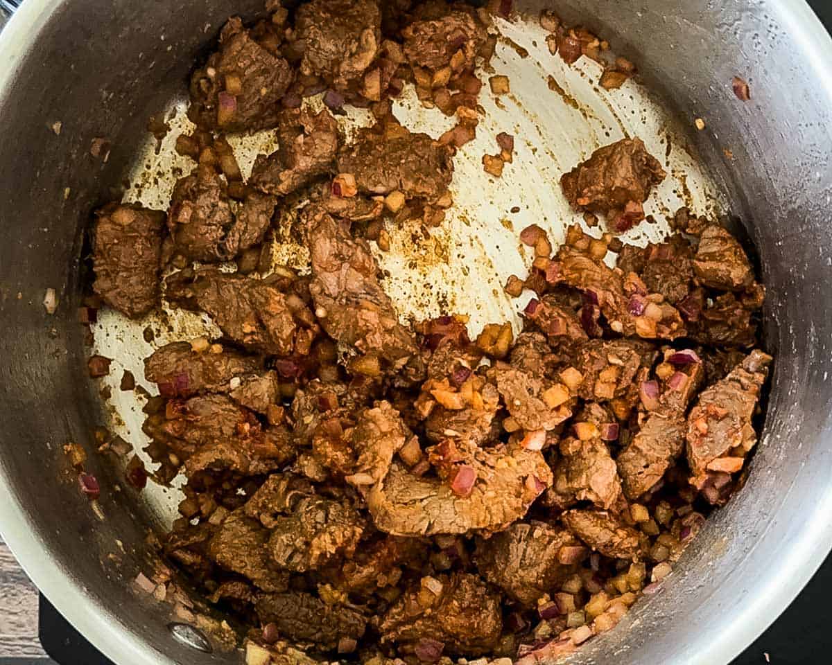 Beef chuck browned in a Dutch oven, showing deep color from searing to build flavor.