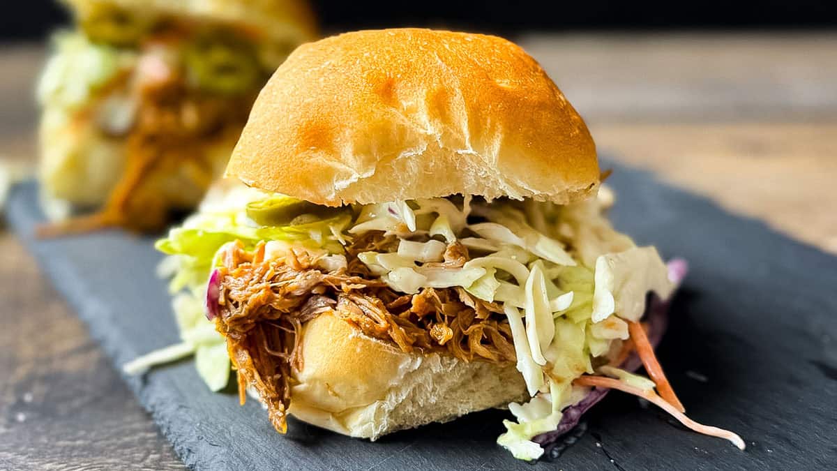 BBQ pulled pork sandwich with creamy coleslaw on a soft bun.