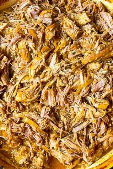 BBQ braised Dutch oven pulled pork, shredded and tossed in rich barbecue sauce inside a cast iron pot.
