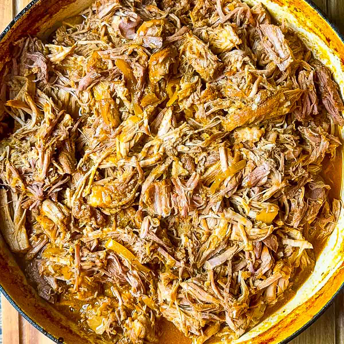 BBQ braised Dutch oven pulled pork, shredded and tossed in rich barbecue sauce inside a cast iron pot.