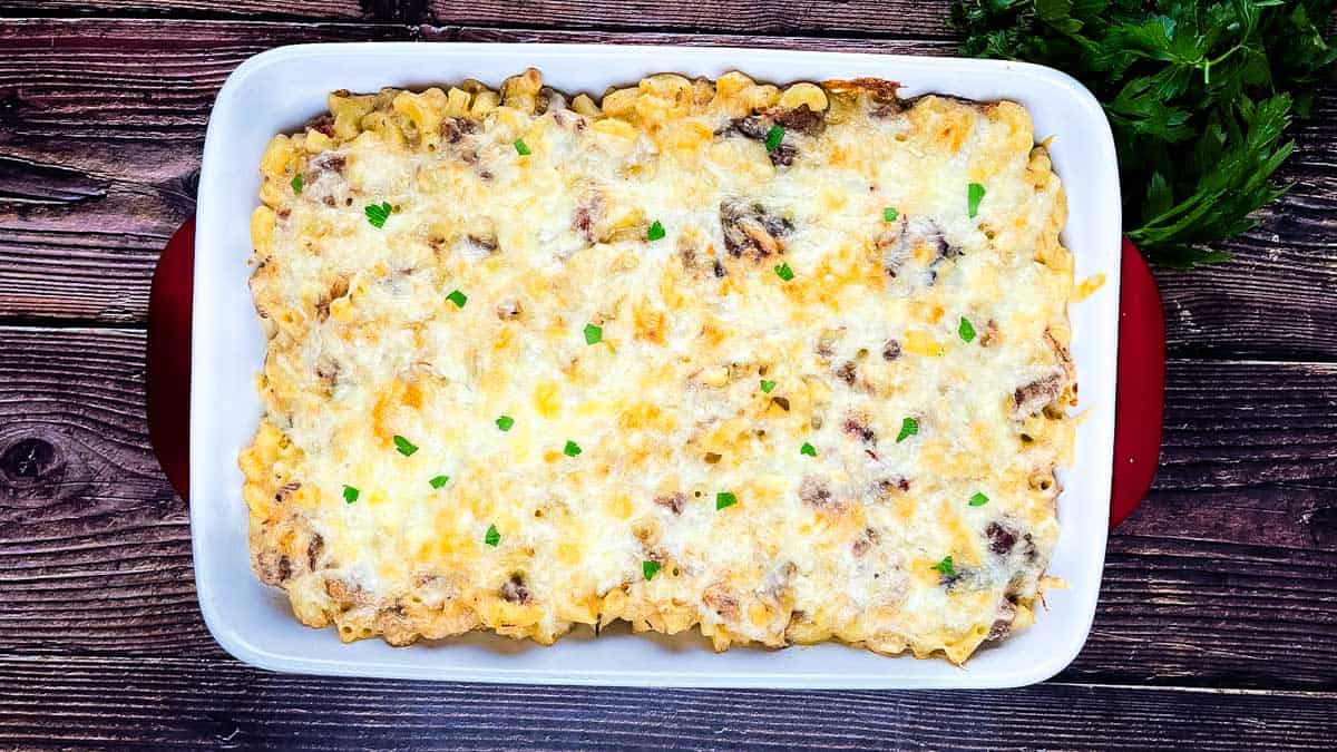 Baked brisket mac and cheese with melted cheese and tender brisket pieces in a casserole dish.