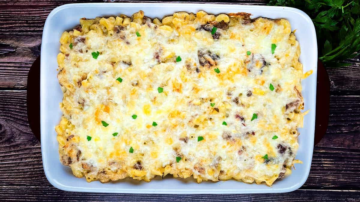 Baked brisket mac and cheese with melted cheese and tender brisket pieces in a casserole dish.