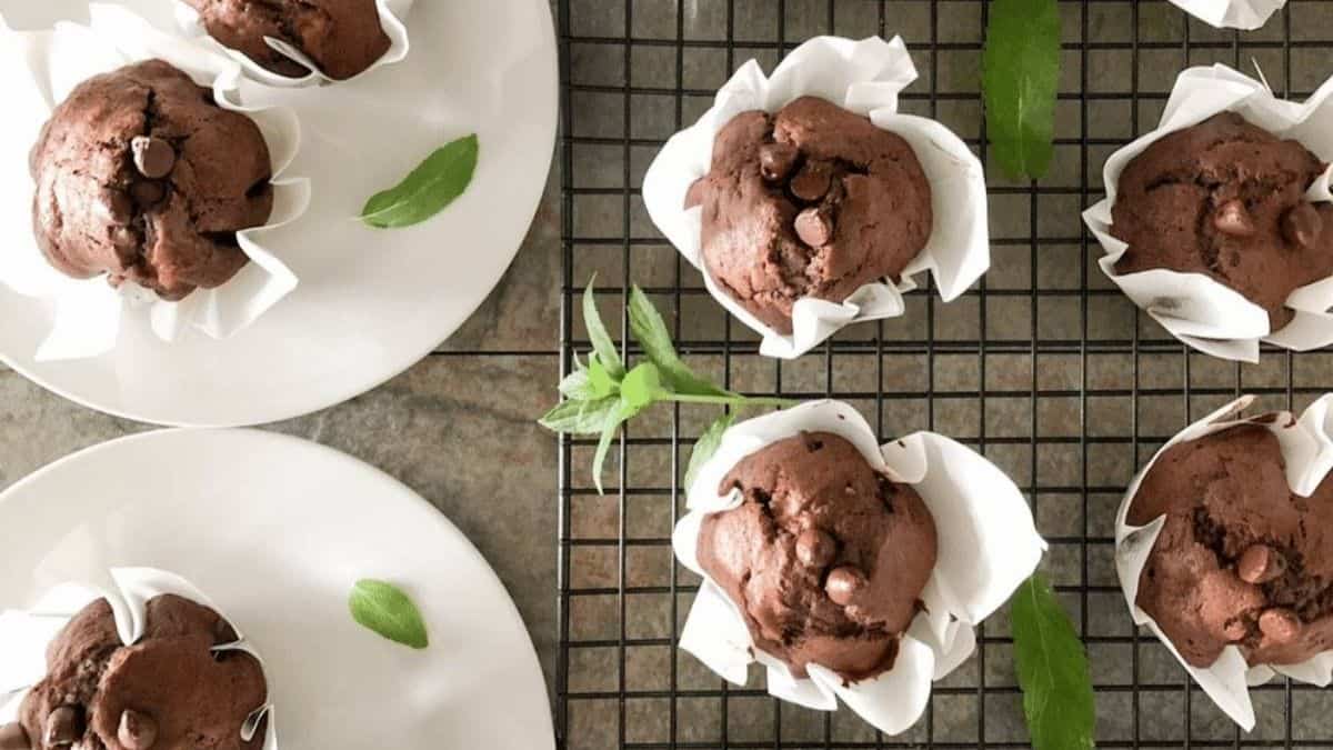 Bakery-style chocolate banana muffins on a white plate.