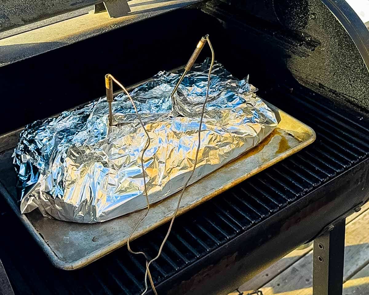 Brisket wrapped in foil with probes inserted during the high-heat cook.