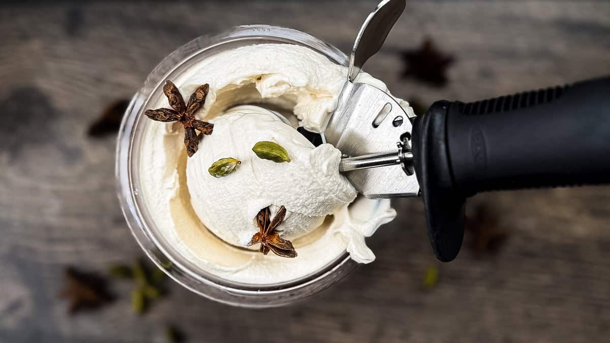 Top view of Ninja Creami chai ice cream in pint container garnished with star anise and cardamom pods.