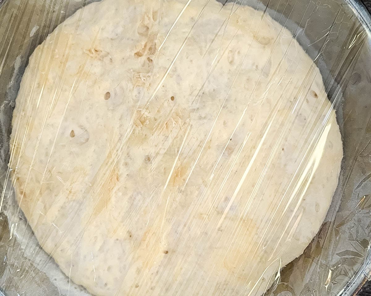 Dough in a large bowl after the first rise, puffy and doubled in size.