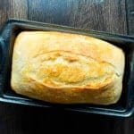 No knead sourdough sandwich bread baked in a loaf pan with a soft, fluffy crumb and golden crust.
