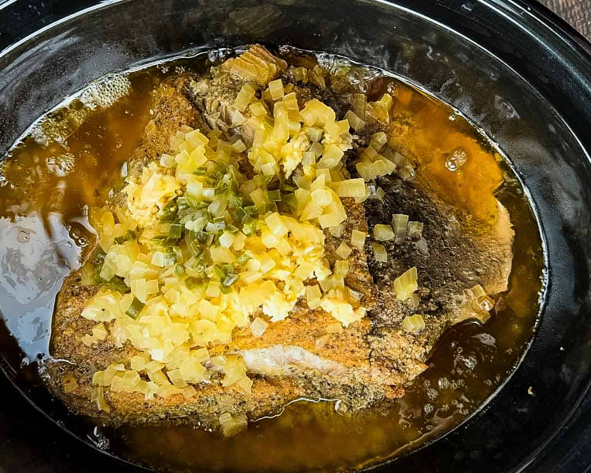 The pork shoulder fully cooked in the slow cooker, ready to shred.