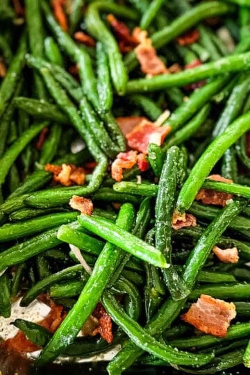 Green beans with bacon and onion in a foil pan just removed from the pellet smoker.
