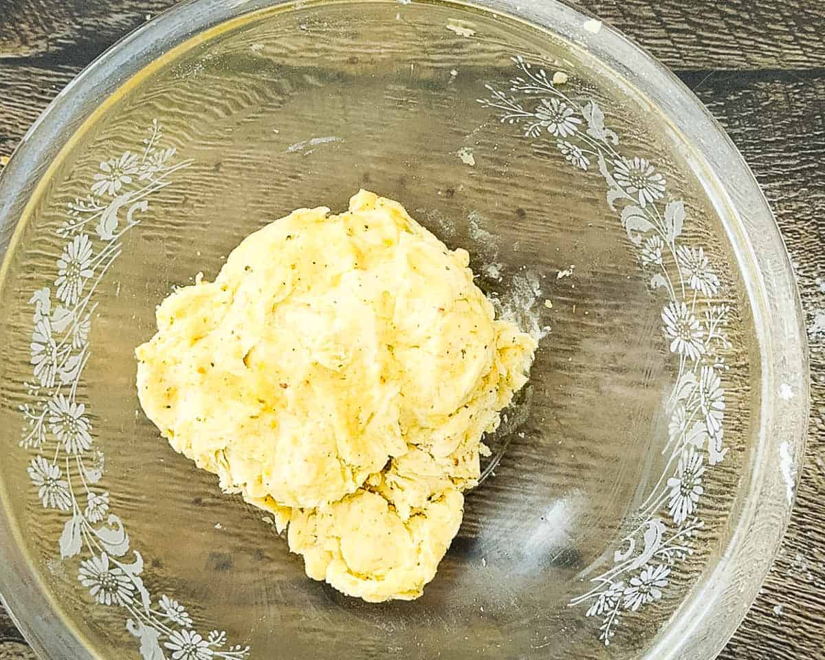 The ingredients combined in a glass mixing bowl until they formed a smooth round ball.