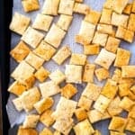 Homemade sourdough discard crackers baked until golden and crispy on a parchment-lined baking sheet.
