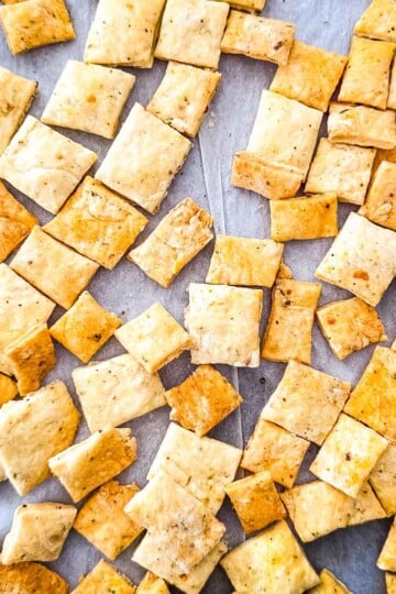 Homemade sourdough discard crackers baked until golden and crispy on a parchment-lined baking sheet.