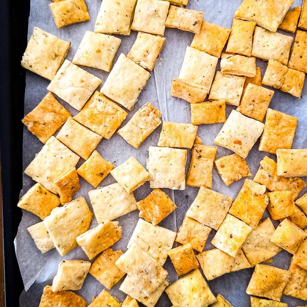 Homemade sourdough discard crackers baked until golden and crispy on a parchment-lined baking sheet.