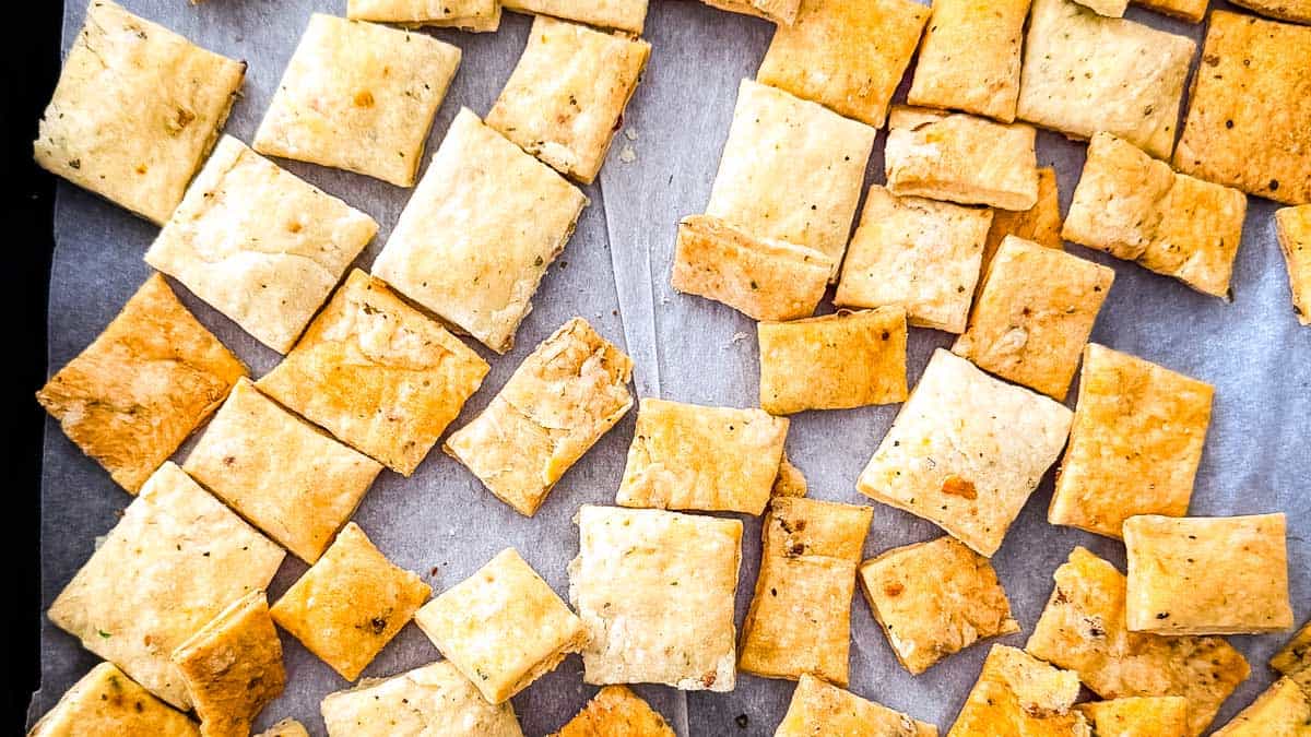 Crispy golden brown discard crackers cooling on a baking sheet.