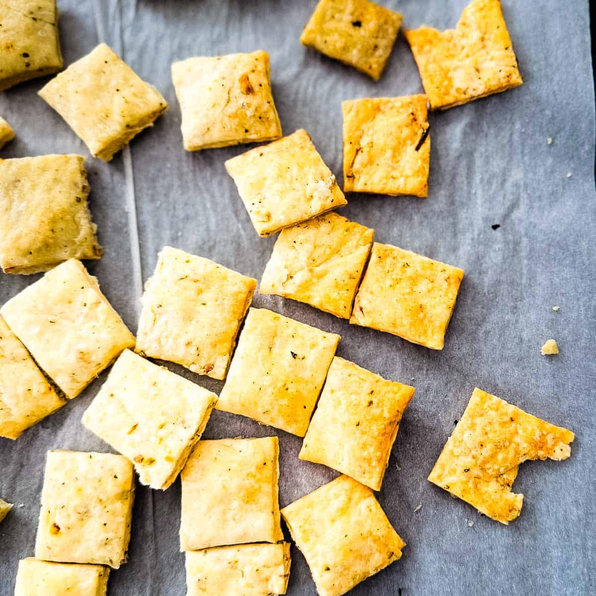 Close-up of homemade sourdough crackers with golden brown edges and flaky layers.