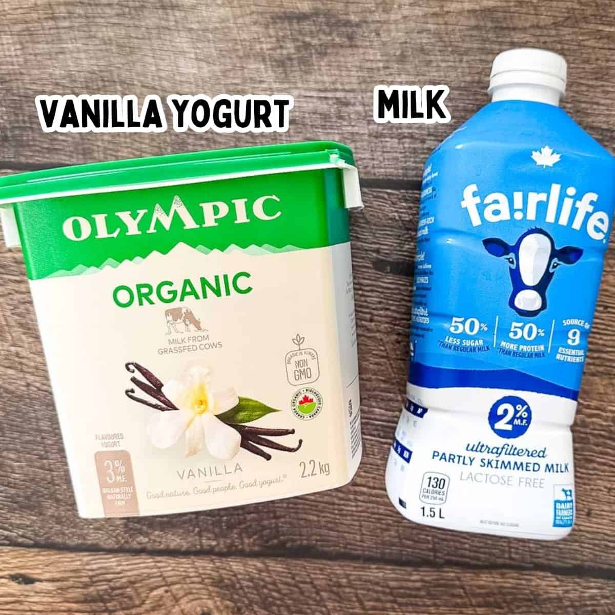 Ingredients for Ninja Creami frozen vanilla yogurt including a large container of Olympic Organic Vanilla Yogurt and a bottle of Fairlife 2% ultra-filtered milk on a wooden background.