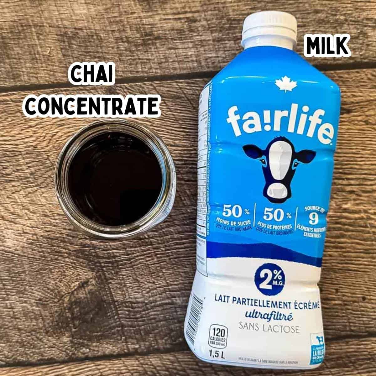 Labeled ingredients for a Starbucks chai tea latte copycat, including chai concentrate and milk, on a wooden surface.