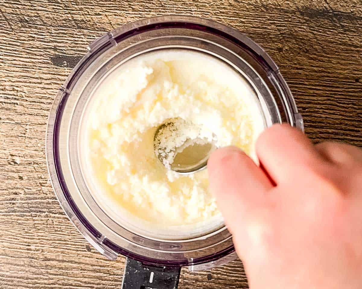 Making a well in the center of the crumbly frozen yogurt after the first spin in the Ninja Creami.