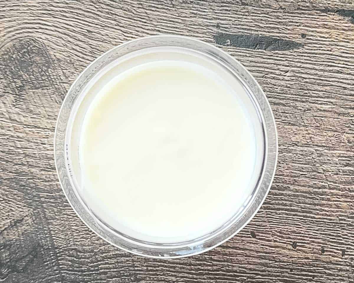 The leveled vanilla yogurt and Fairlife milk mixture in the Ninja Creami container before freezing.