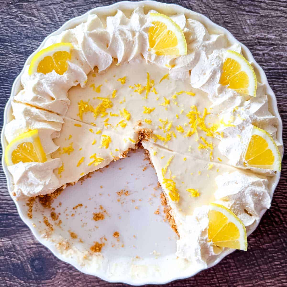 A sliced No-Bake Lemon Cream Pie showing the firm, silky texture of the lemon filling and the buttery graham cracker crust.