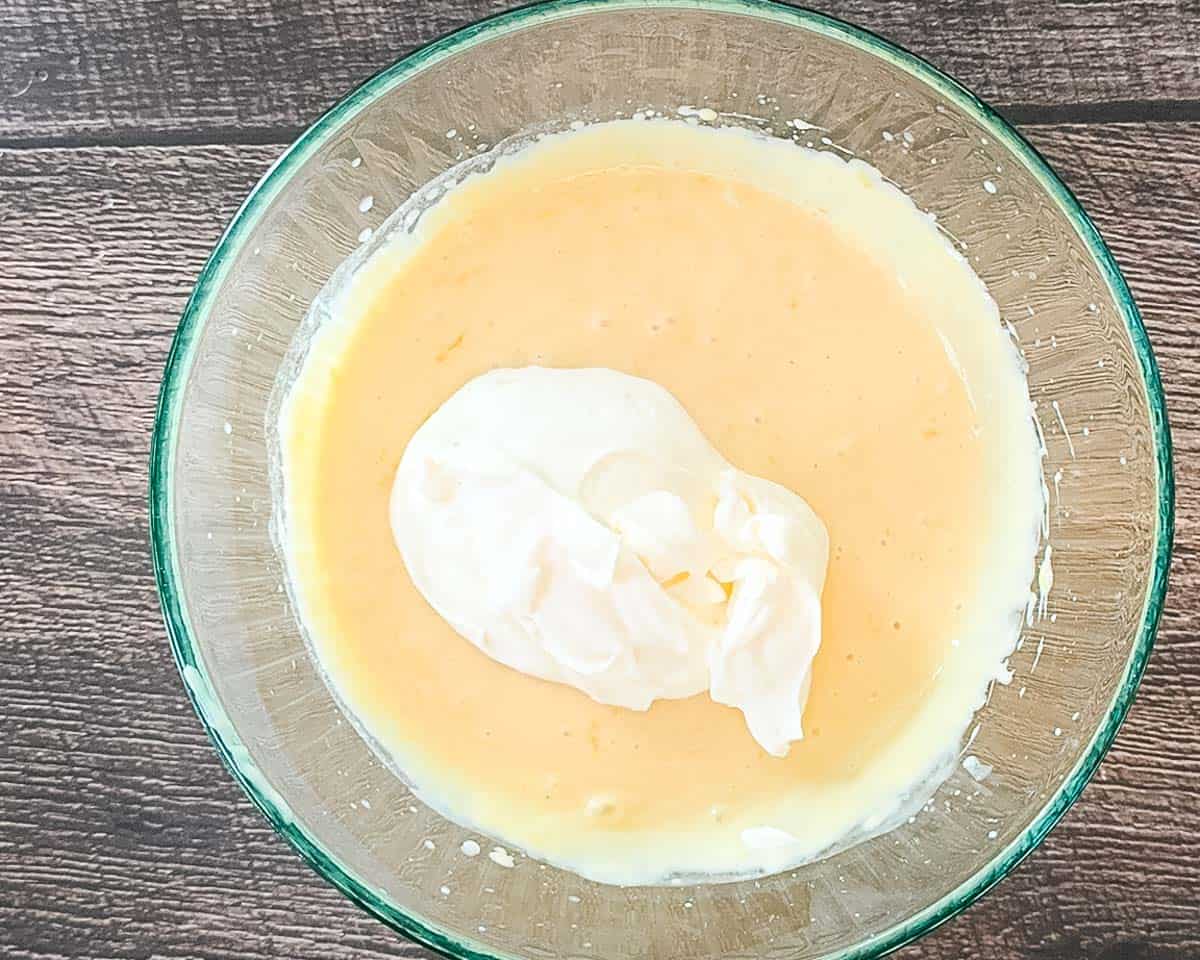 Adding the whipped heavy cream into the lemon and condensed milk mixture.