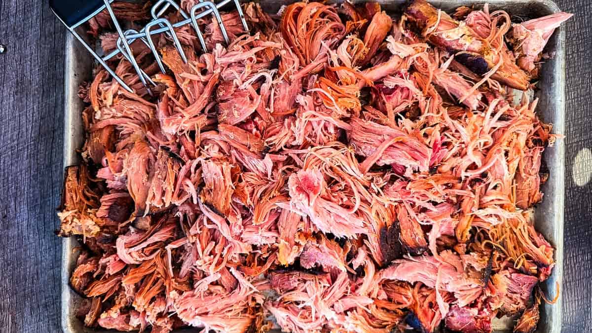 Shredding smoked ham with meat claws.
