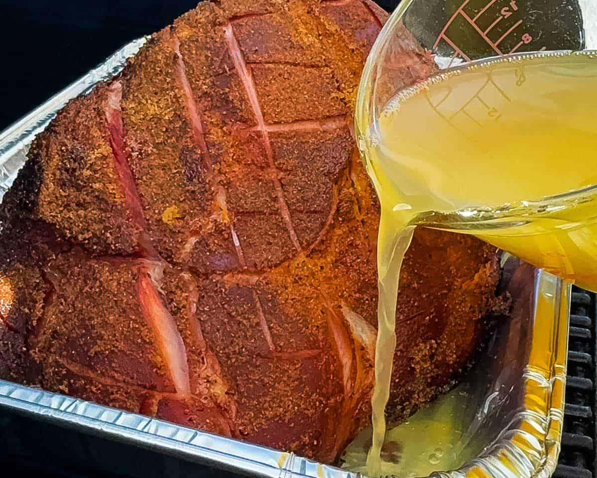 Ham in foil pan with pineapple juice before covering.