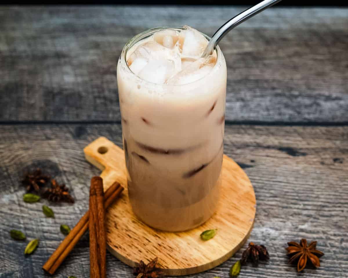 Iced chai tea latte fully mixed with ice and straw.
