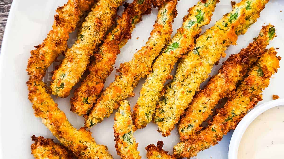 The crispy green bean fries on a white dinner plate.