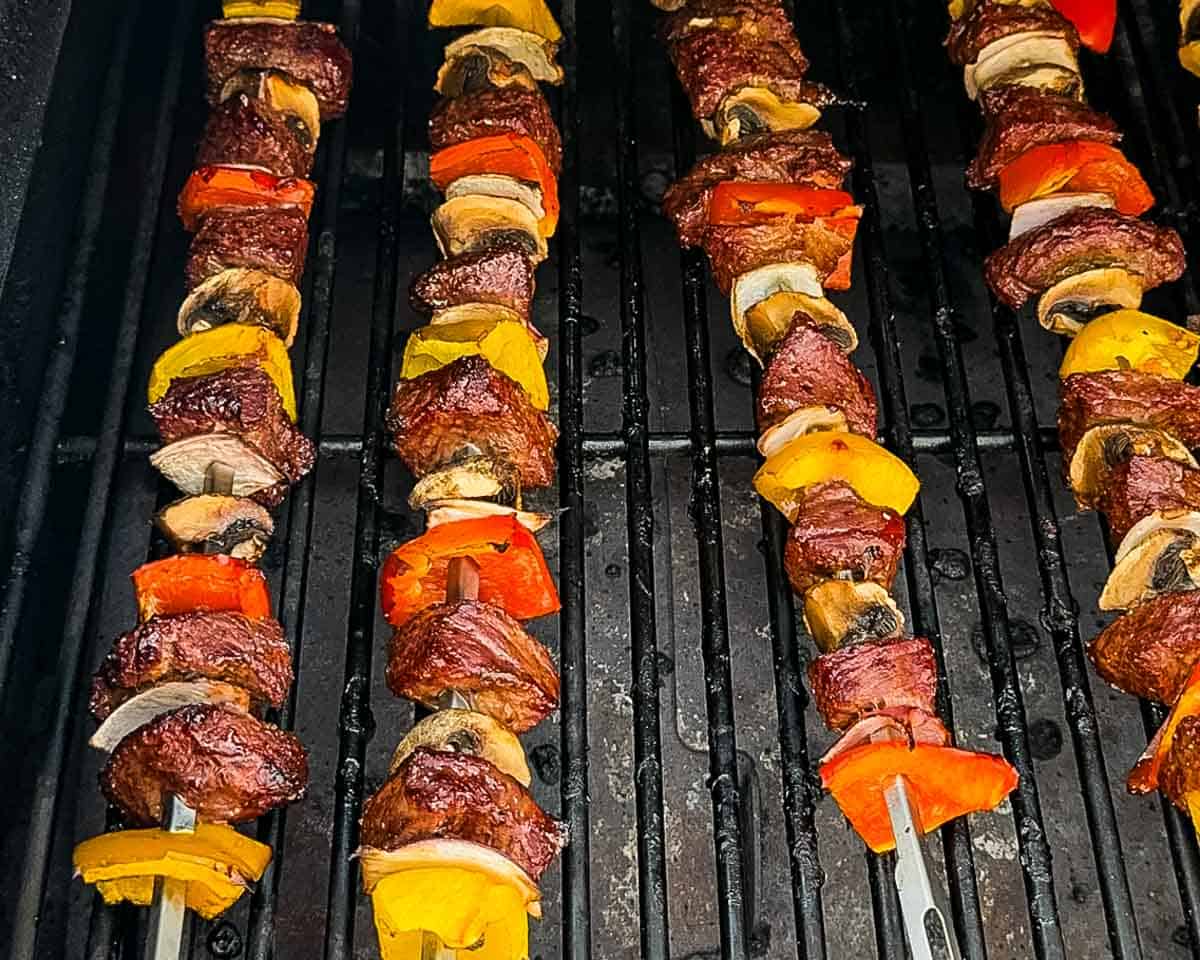 Steak kabobs searing on a hot pellet grill.